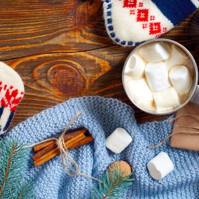 Что подарить папе на новый год - варежки, носки, сладости в коробке на деревянной доске и голубом свитере с елочной веткой в подарок на НГ